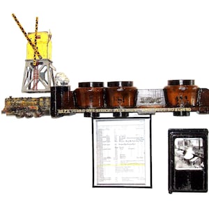 May include: A wooden train set with a yellow signal tower, a black and brown train, and a sign that reads "Rope Guard One Ticket Train Not Less Than 70".