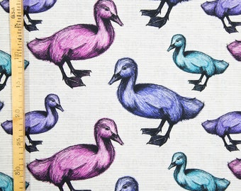 May include: A white fabric with a repeating pattern of ducks in shades of purple, blue, and teal. The ducks are drawn in a stylized, almost cartoon-like fashion.