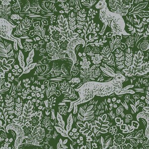 May include: A repeating pattern featuring white hares and squirrels amidst foliage, flowers, and mushrooms on a dark green background. The design has a woodcut style, creating a textured, natural aesthetic. The overall theme is nature and wildlife.