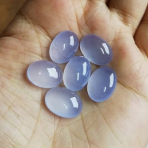 Może przedstawiać: Sześć owalnych, p&oacute;łprzezroczystych, jasnoniebieskich kamieni szlachetnych. Kamienie szlachetne są gładkie i wypolerowane.