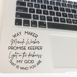 Può includere: Un laptop bianco con un adesivo nero sul touchpad. L'adesivo dice "Way Maker, Miracle Worker, Promise Keeper, Light in the darkness, That is who you are, My God".