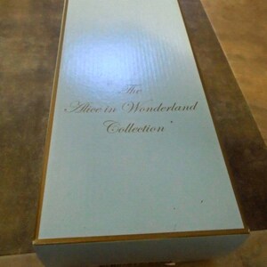 May include: A light blue box with gold trim. The text "The Alice in Wonderland Collection" is printed on the box.
