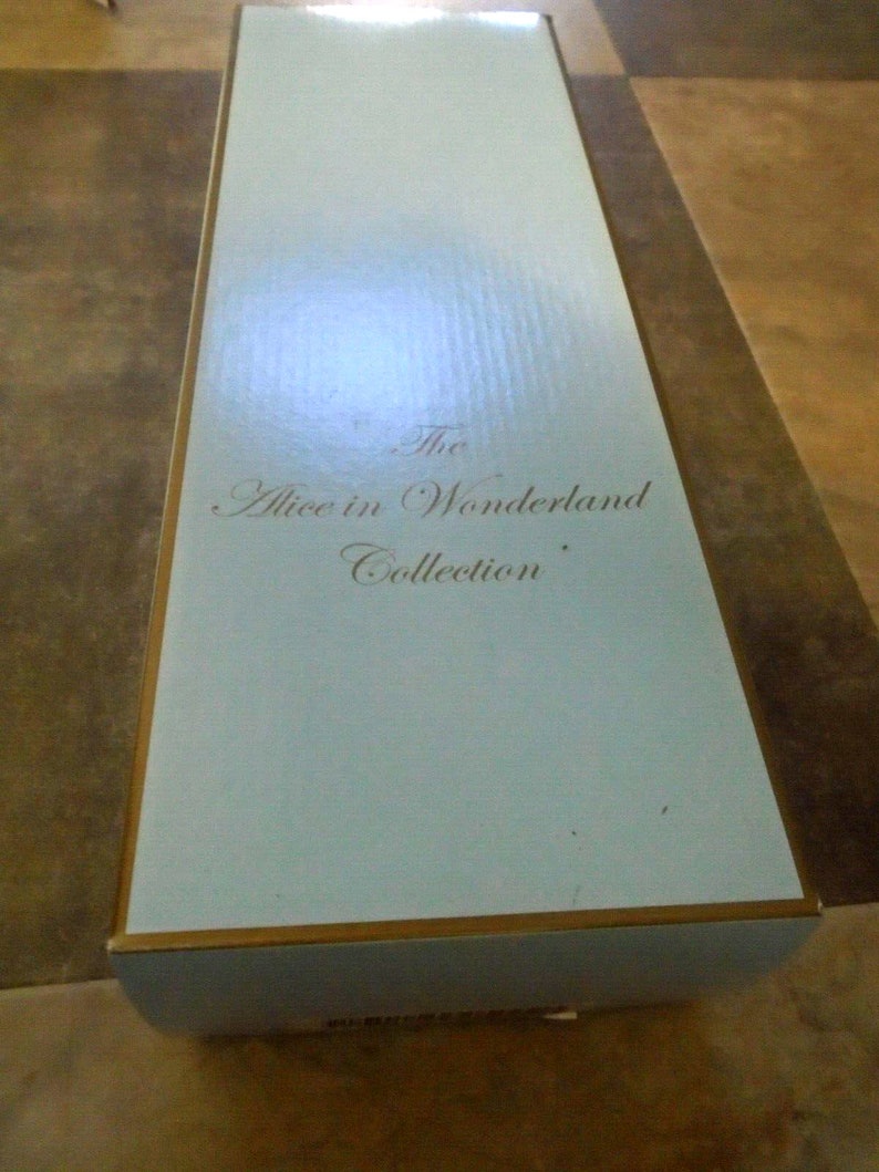 May include: A light blue box with gold trim. The text "The Alice in Wonderland Collection" is printed on the box.