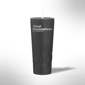 May include: A black tumbler with a white straw. The tumbler has a silver rim and the words "The Real Housewives of Your City" in white text. The tumbler has a faceted design.