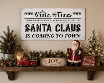 May include: A rectangular white sign with black text reading: EXTRA! The Winter Times EXTRA! NEWS FROM THE NORTH POLE DEC. 24 SANTA CLAUS IS COMING TO TOWN. The sign features a distressed finish and is displayed above a wooden shelf with holiday decor.