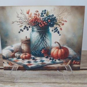 May include: Watercolor painting of a still life with a blue glass jar filled with branches, red berries, and dark blue berries. Pumpkins, a small wooden barrel, and a patterned quilt are also featured. The color palette includes shades of blue, orange, and brown.