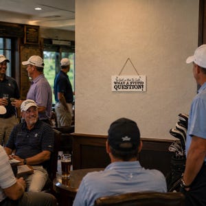 May include: A rectangular white wooden sign hanging on a wall with black text that reads: To Golf or Not To Golf... WHAT A STUPID QUESTION! The sign is suspended by a thin piece of twine and features small black star accents above the text.
