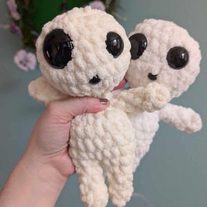 Cream colored crocheted Kodoma in front of the white version. For comparison purposes. The cream is a warmer color, but extremely similar.