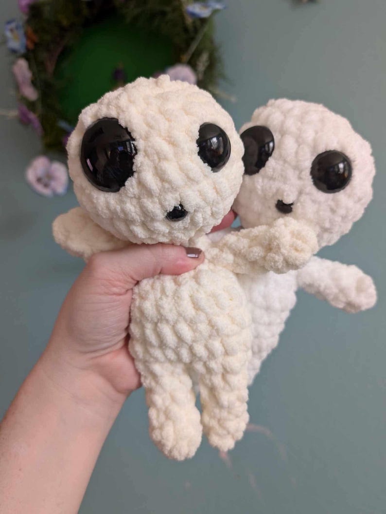 Cream colored crocheted Kodoma in front of the white version. For comparison purposes. The cream is a warmer color, but extremely similar.