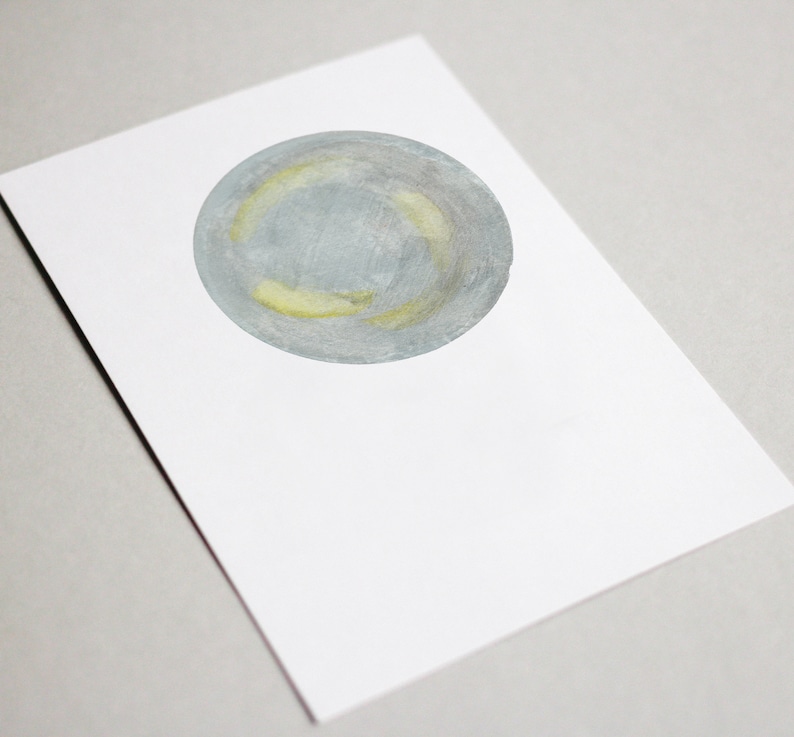 May include: A watercolor painting of a gray and yellow circle on a white background.
