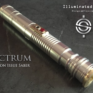 May include: A silver lightsaber with a gold tip and a red button. The lightsaber is labeled "ELECTRUM BATTALION ISSUE SABER".