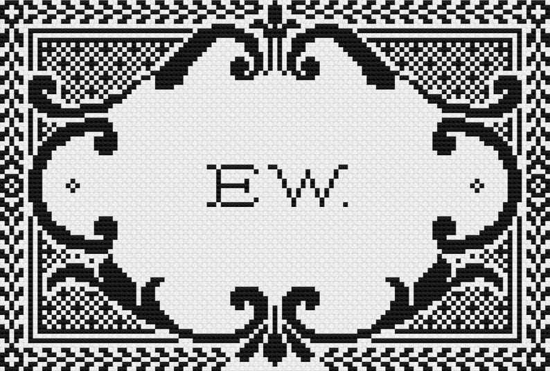 May include: A black and white cross stitch pattern featuring a central oval frame with ornate scrollwork borders. The letters E and W are centered within the frame, followed by a period. The design is set against a grid background.
