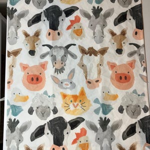 May include: White fabric featuring a repeating pattern of farm animals. The design includes cows, pigs, sheep, donkeys, chickens, ducks, a cat, and a rabbit, all in watercolor style. The animals are in various colors, including black, white, orange, and gray.