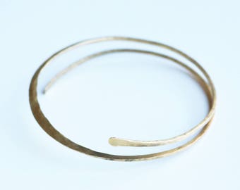 May include: A gold-toned double-strand bangle bracelet with a hammered finish.
