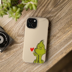 Capa para iPhone MagSafe resistente Grinch com pequeno coração vermelho