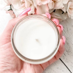 a person holding a glass jar with a candle in it