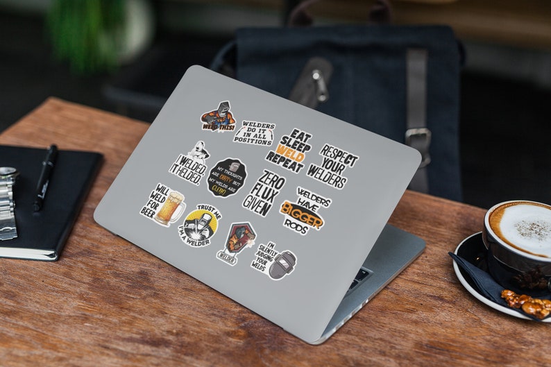 May include: A set of 11 welder themed stickers featuring various designs and sayings, including "I welded it, I welded it", "Will weld for beer", "Trust me I'm a welder", "Welders have bigger rods", "Zero flux given", "My thoughts are dirty but my welds are clean", "Welders do it in all positions", "Eat sleep weld repeat", "Respect your welders", and "I'm silently judging your welds". The stickers are on a silver laptop.