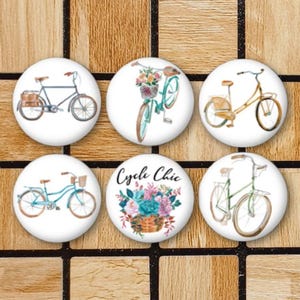 May include: Six white, round magnets featuring bicycle illustrations. The designs include bicycles with baskets, flowers, and the text "Cycle Chic". The colour palette includes blue, brown, and green.