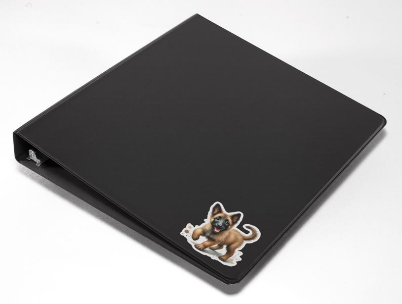 May include: Black binder with a sticker of a brown and black puppy on the front.