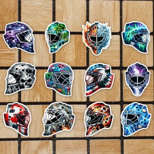 May include: Twelve colourful goalie masks with different designs. The masks are all white with various colours and patterns, including skulls, flames and stars.