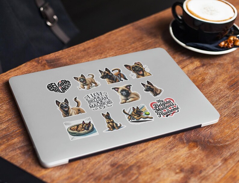 May include: A silver laptop computer with a variety of stickers featuring Belgian Malinois dogs. The stickers include images of the dogs, text that says "I love Belgian Malinois" and "My Belgian Malinois is Pawsome", and a heart with the words "Belgian Malinois".