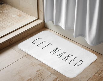 Pode incluir: Tapete de banho branco com o texto "GET NAKED" impresso em preto.