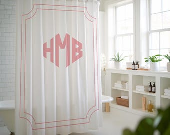 May include: White shower curtain with a pink monogram of the letters "HMB" in a decorative frame.