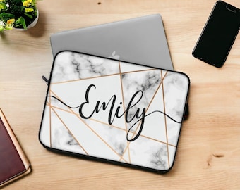 May include: A white and gray marble-patterned laptop sleeve with gold geometric lines and the name "Emily" in black script. The sleeve is on a wooden surface with a laptop, phone, and small plant.