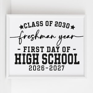 May include: A white framed print with black text. The text says "CLASS OF 2030, freshman year, - FIRST DAY OF - HIGH SCHOOL 2026-2027". The text uses a mix of fonts, with "CLASS OF" and "HIGH SCHOOL" in a bold, blocky font.