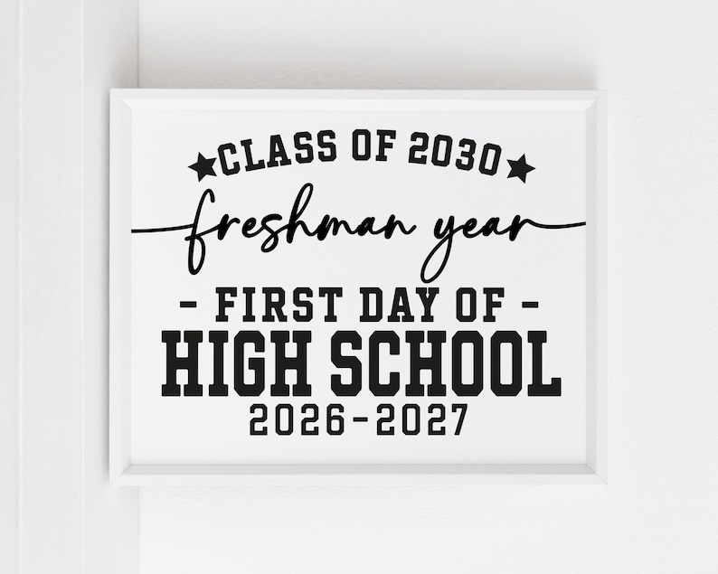 May include: A white framed print with black text. The text says "CLASS OF 2030, freshman year, - FIRST DAY OF - HIGH SCHOOL 2026-2027". The text uses a mix of fonts, with "CLASS OF" and "HIGH SCHOOL" in a bold, blocky font.