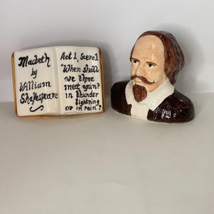 May include: A ceramic figurine set featuring a bust of William Shakespeare and a miniature book. The book is open, displaying the title "Macbeth" and a quote from Act 1, Scene 1. The bust is brown and white, with a mustache and beard.