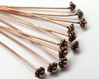 May include: A group of 10 copper head pins with a decorative, textured, flower-shaped head. The pins are approximately 1 inch long.