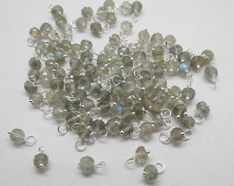 May include: A pile of silver-toned beads with a light gray gemstone and a silver loop attached to each bead.