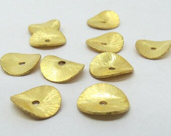 May include: A collection of nine gold-colored metal beads with a hole in the center. The beads are shaped like a leaf and have a textured surface.