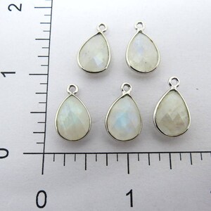 May include: Five silver teardrop-shaped pendants with white moonstone gemstones.