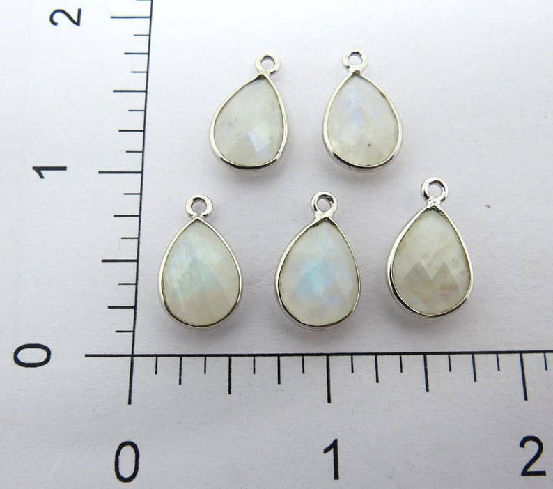 May include: Five silver teardrop-shaped pendants with white moonstone gemstones.