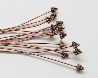 May include: A bunch of copper-colored head pins with a cluster of small beads at the end of each pin.