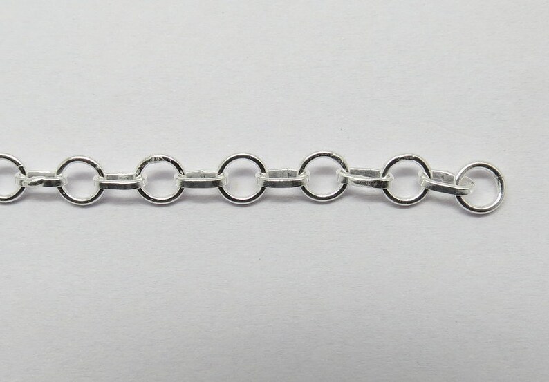 Op de afbeelding: Een zilveren ketting met ronde schakels. De ketting is gemaakt van metaal en heeft een gepolijste afwerking.