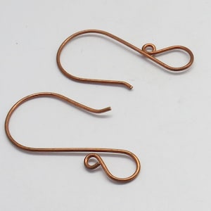 Può includere: Un paio di ganci per orecchini color rame. I ganci sono realizzati in filo sottile e flessibile e hanno un design semplice ed elegante.