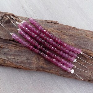 May include: Multiple strands of pink ruby beads on silver wire. The beads are faceted and have a slightly irregular shape.