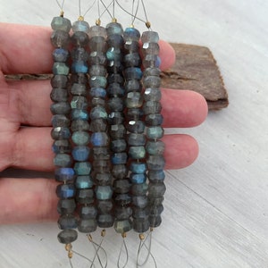 Puede incluir: Seis hebras de cuentas de labradorita facetadas de color gris oscuro con lazos de alambre dorado. Las cuentas están enhebradas en un alambre fino.