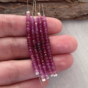 May include: Five strands of pink gemstone beads on silver wire. The beads are faceted and have a square shape.