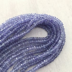 May include: A strand of light purple faceted gemstone beads. The beads are small and round, and they are strung together on a clear thread.