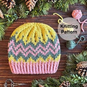 May include: A knitted hat with a pink, green and yellow chevron pattern. The hat is surrounded by pine branches and pine cones. The text "Knitting Pattern" is written in a circle.