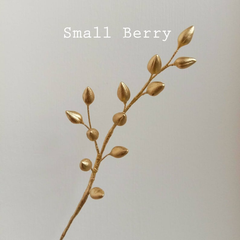 A gold-coloured twig with small, round sugarcraft berries. The twig is bent into a curved shape, and the berries are clustered together. The text "Small Berry" is written above the twig.
