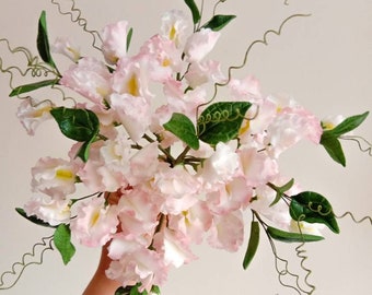 May include: A bouquet of delicate pink sugar flowers with green leaves and vines. The flowers are arranged in a cluster and have a realistic appearance. The text "Bespoke Sugarcraft" is visible in the lower right corner of the image.