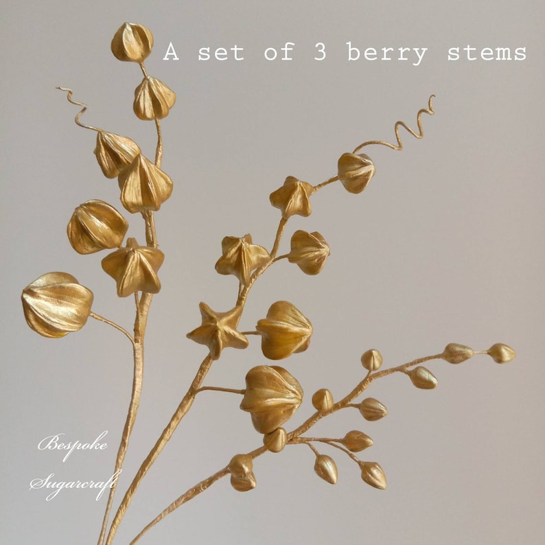 A set of three gold sugarcraft berry stems featuring a range of berry shapes and sizes. The stems are made from wire and are ideal for adding a touch of elegance to any floral arrangement.
