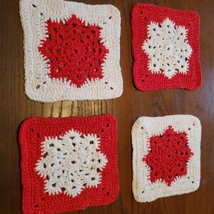 Peut inclure: Quatre torchons carrés en crochet rouge et blanc. Les torchons ont un motif en forme d'étoile au centre.