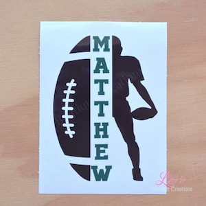 May include: A black and white silhouette of a football player holding a football, with the name "MATTHEW" written vertically in green letters next to the player.
