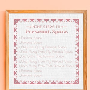 May include: A cross-stitch pattern with a pink border and white background. The pattern reads "Nine Steps to Personal Space" and lists nine steps, each with the phrase "Personal Space" repeated.